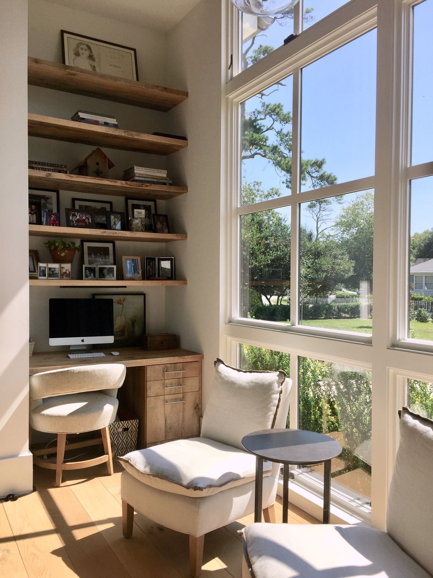 A living room with a couch , chair , desk and windows