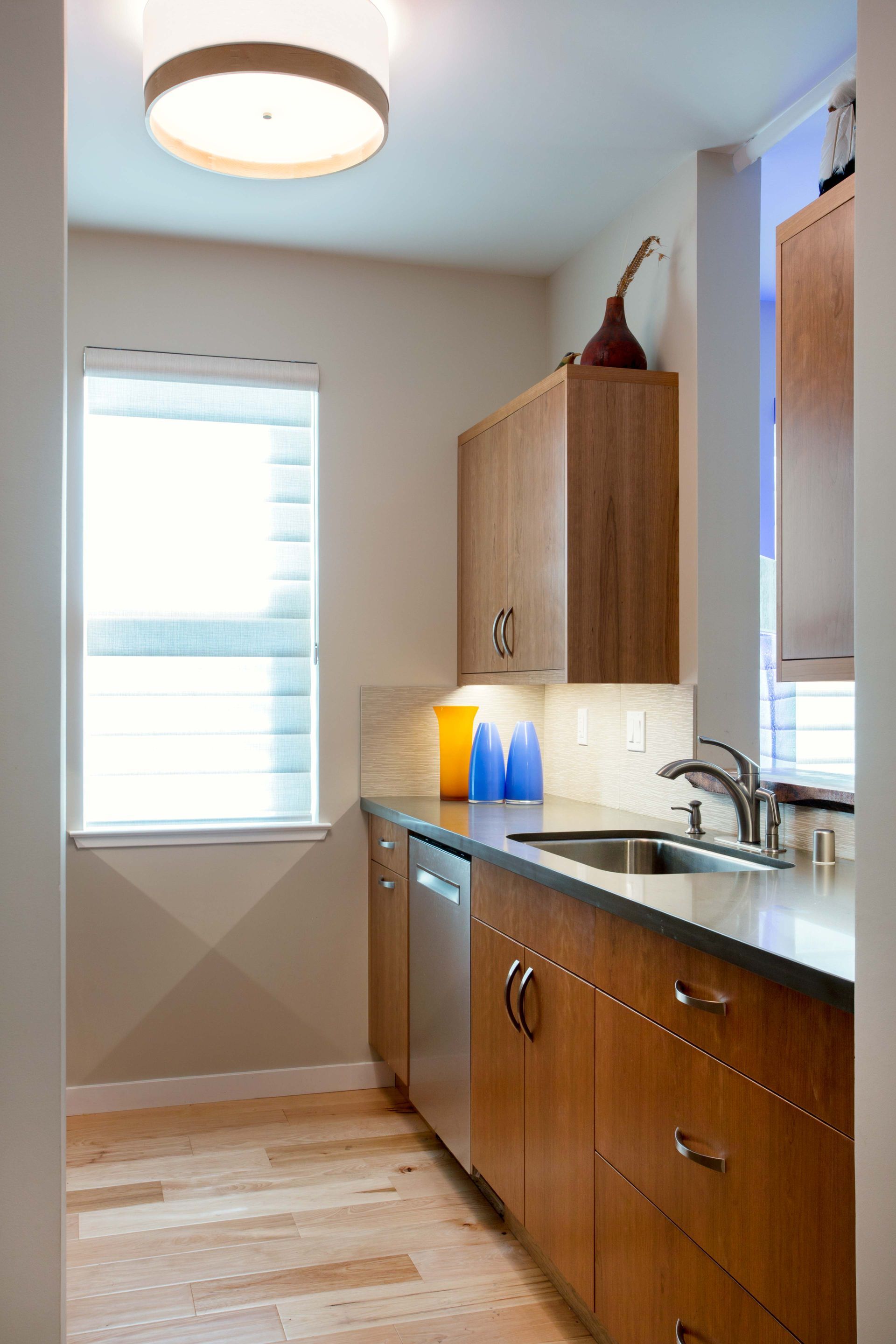 A kitchen with wooden cabinets and a stainless steel dishwasher