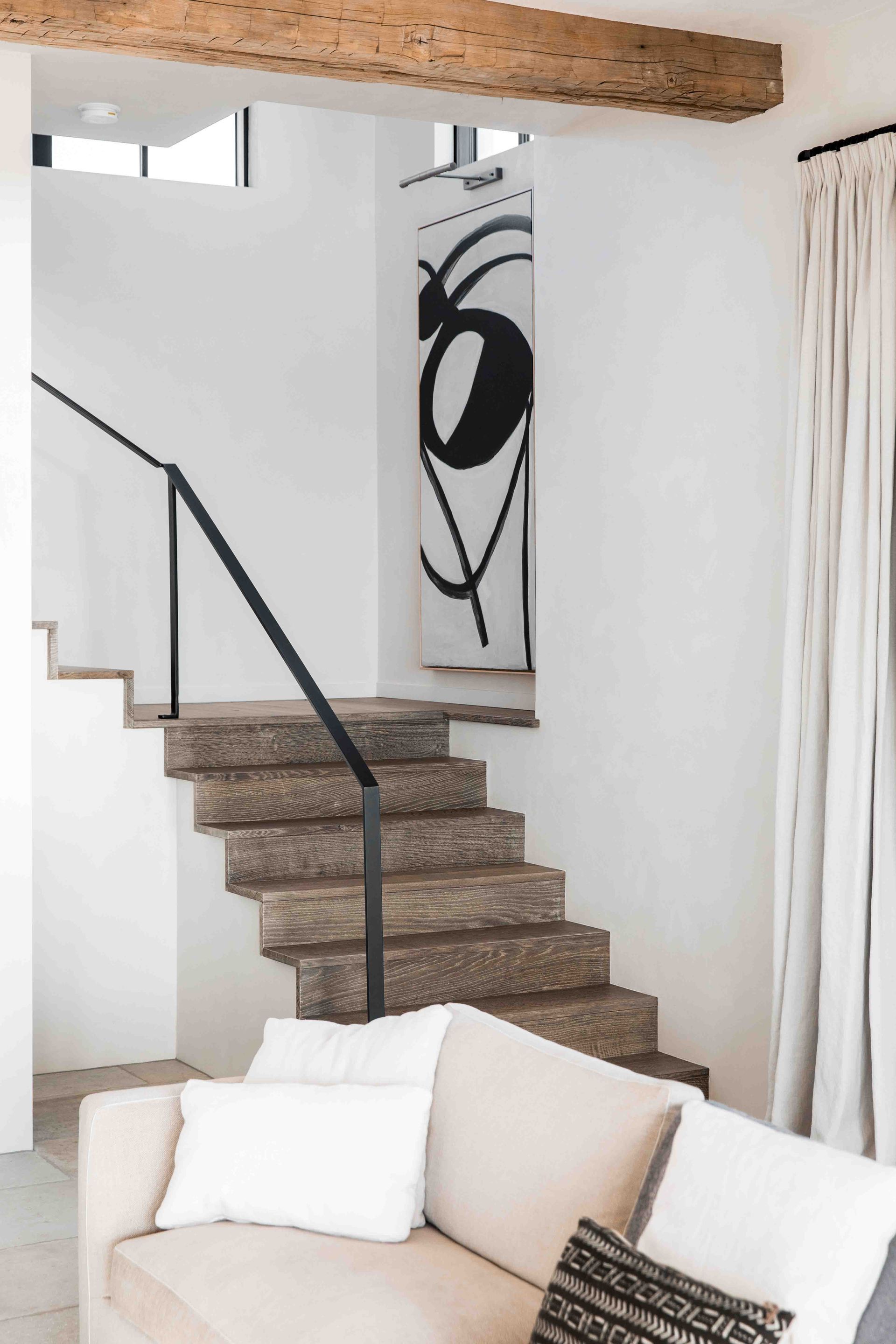 A living room with a couch and stairs leading up to the second floor