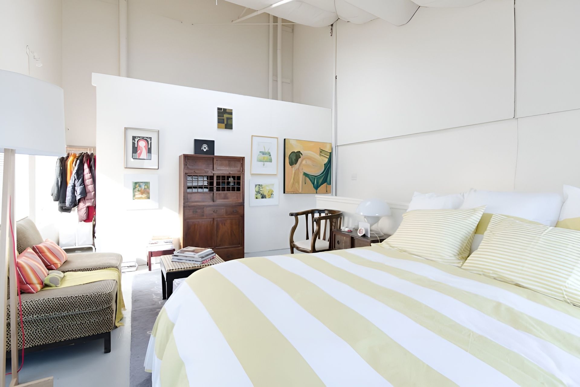 A bedroom with a large bed and a striped comforter