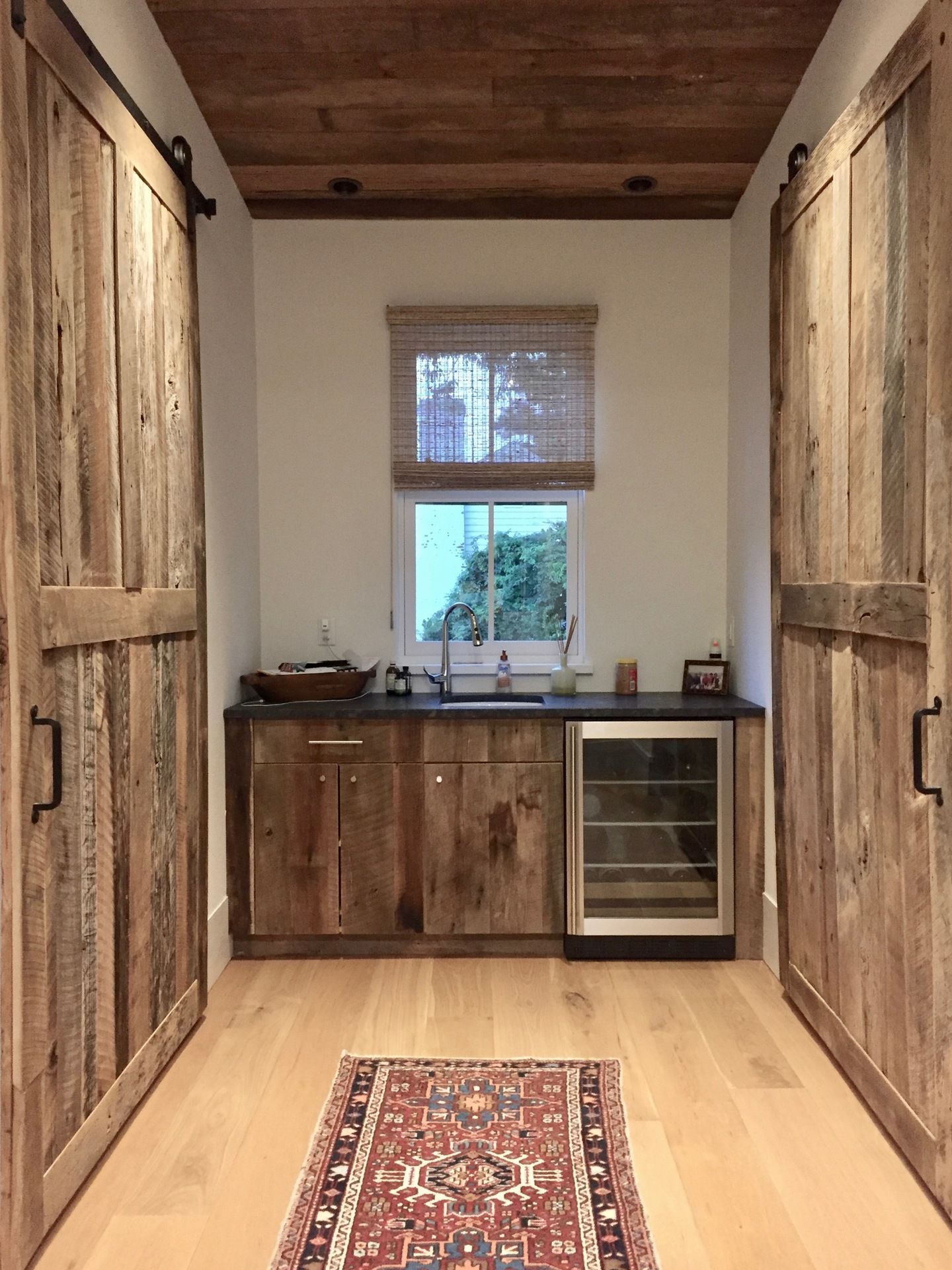 A kitchen with wooden cabinets and sliding barn doors