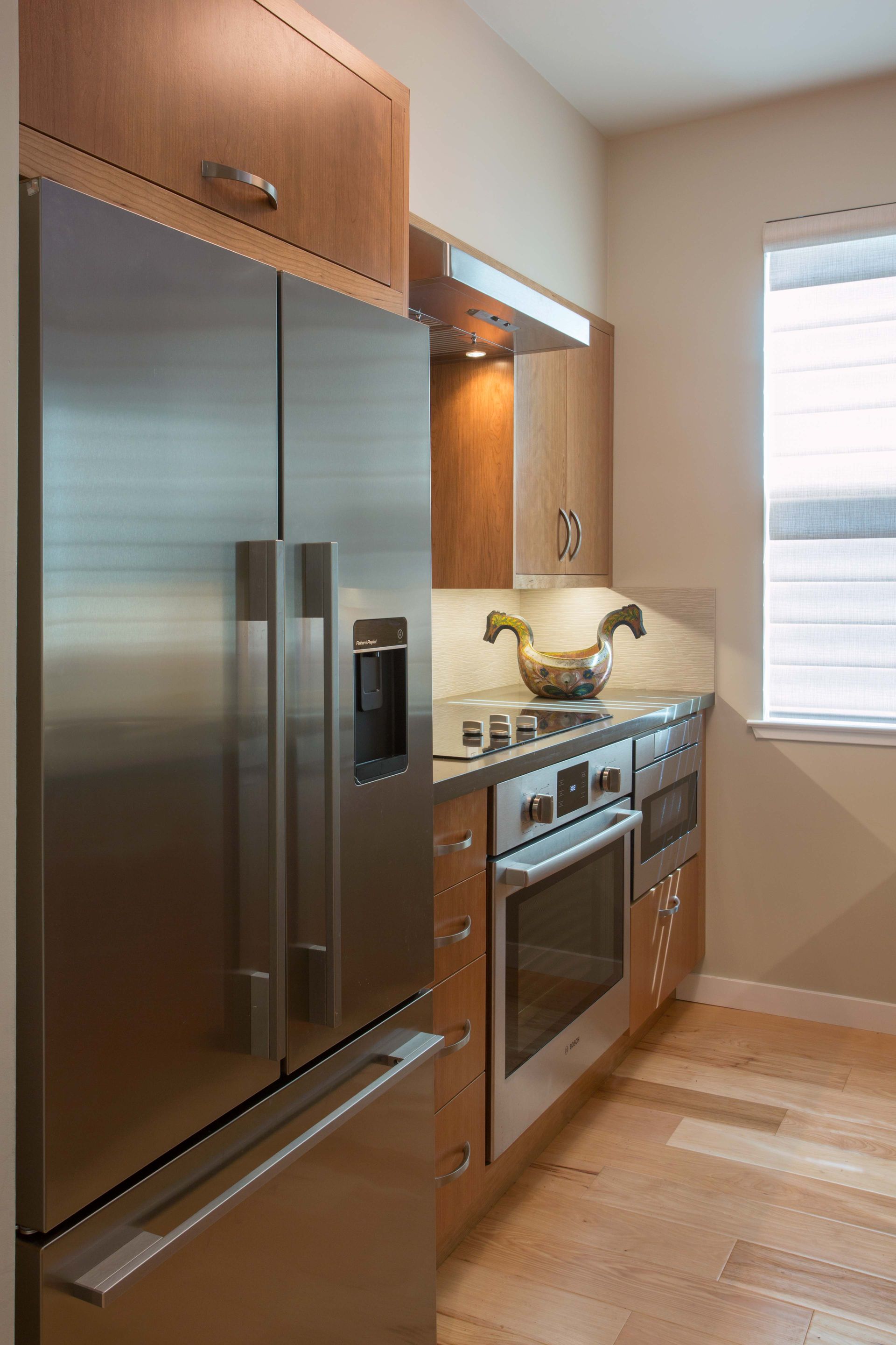 A kitchen with stainless steel appliances and wooden cabinets