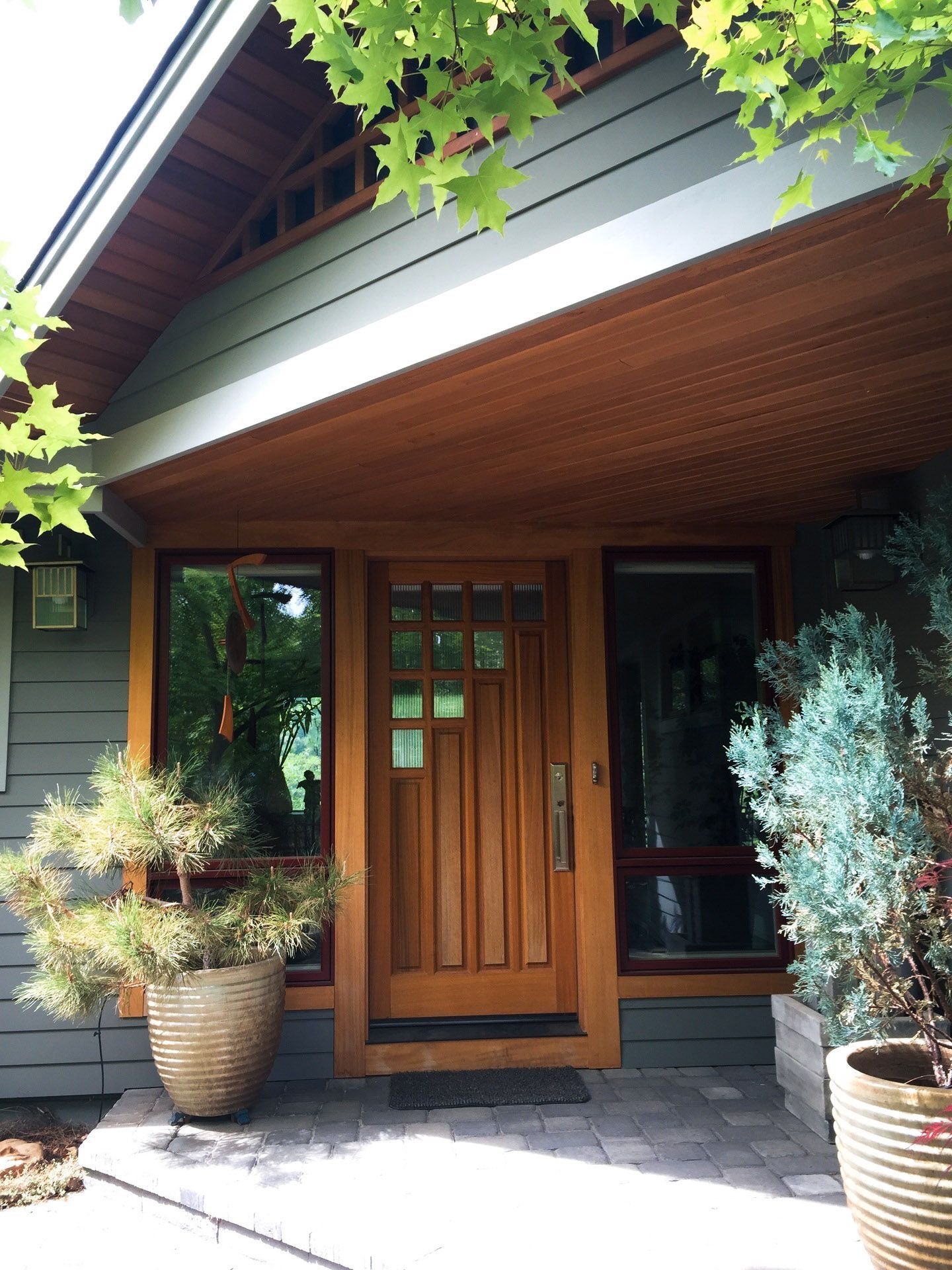 A house with a wooden door and potted plants in front of it