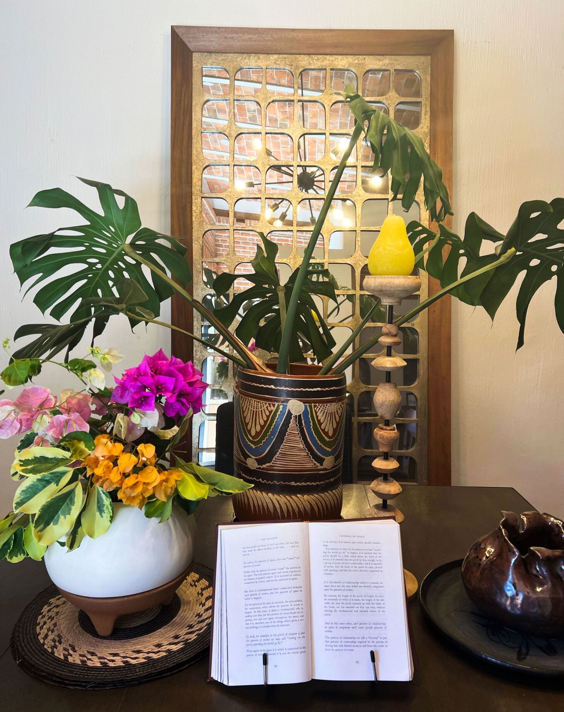 A table with a vase of flowers and a book on it.