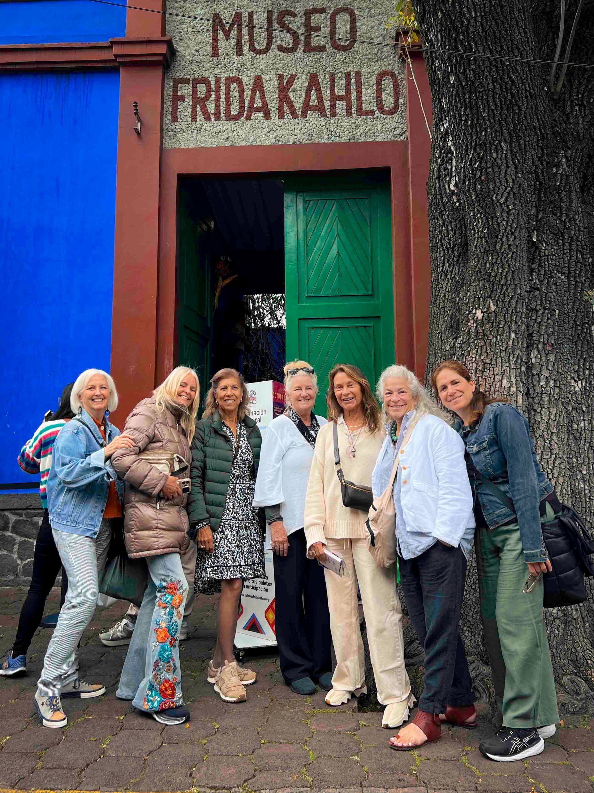 A building in a park in Mexico City with trees and benches in front of it