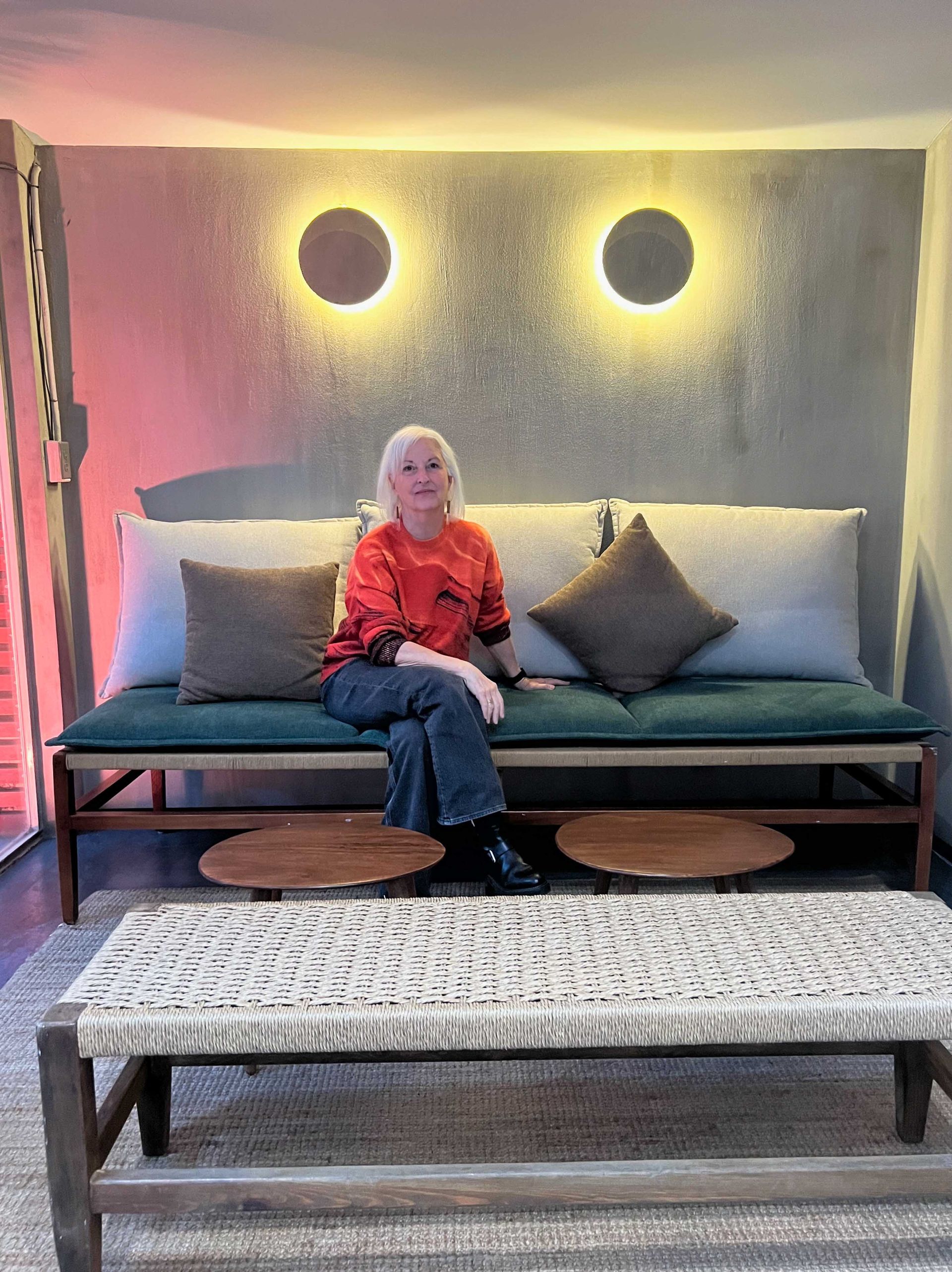 A woman is sitting on a couch in a living room.