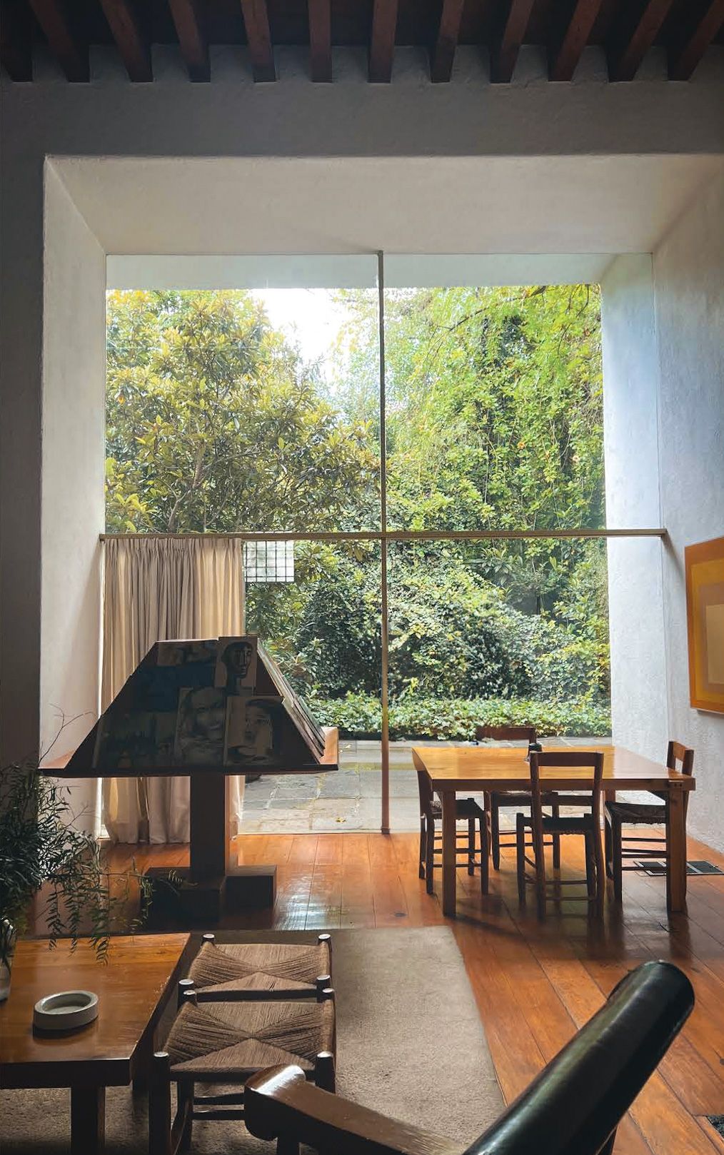 A living room in Luis Barragán's house with a table and chairs and a fireplace.