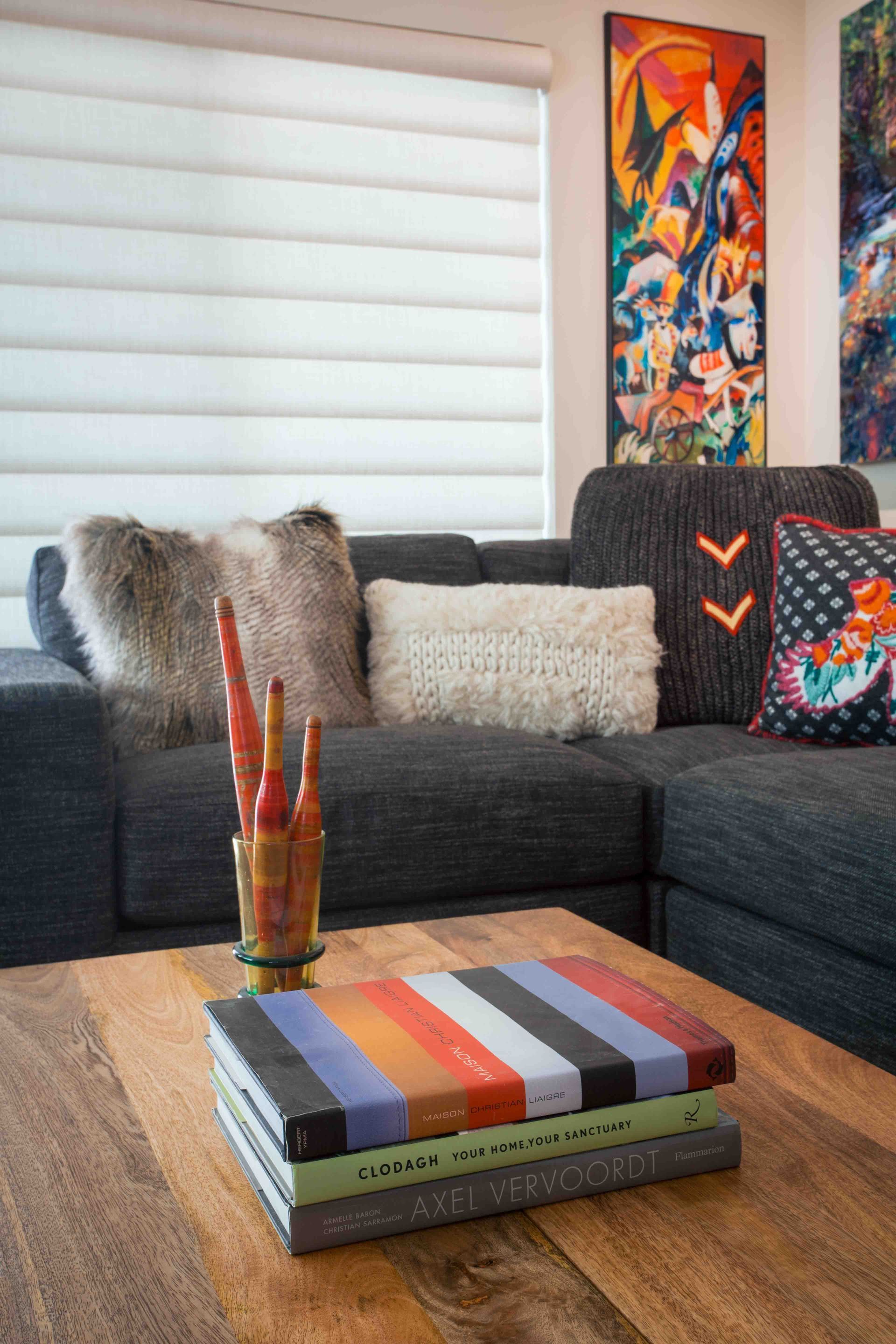 A living room with a couch and a coffee table with books on it.