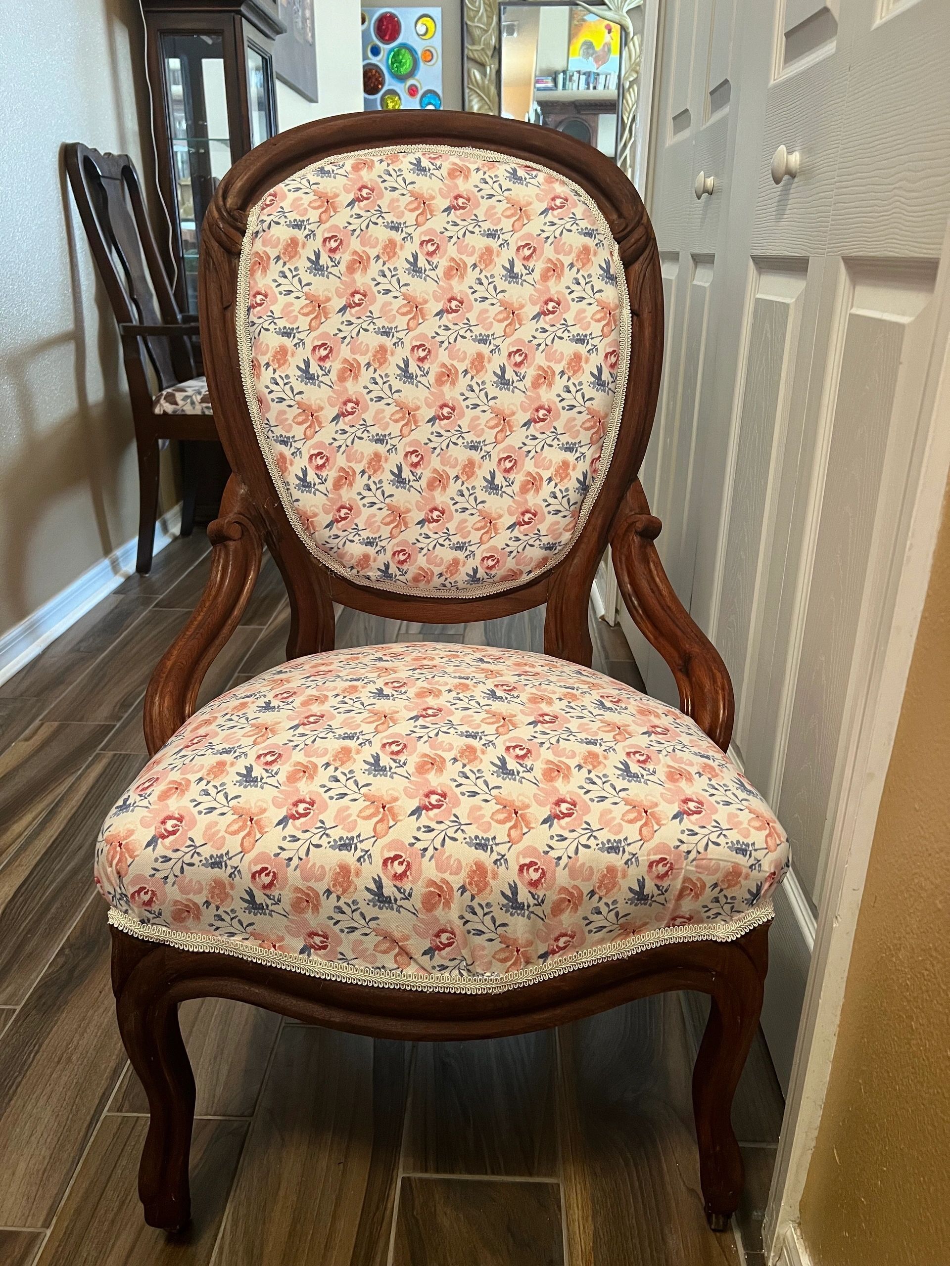 Ornate wooden chair with floral patterned upholstery.