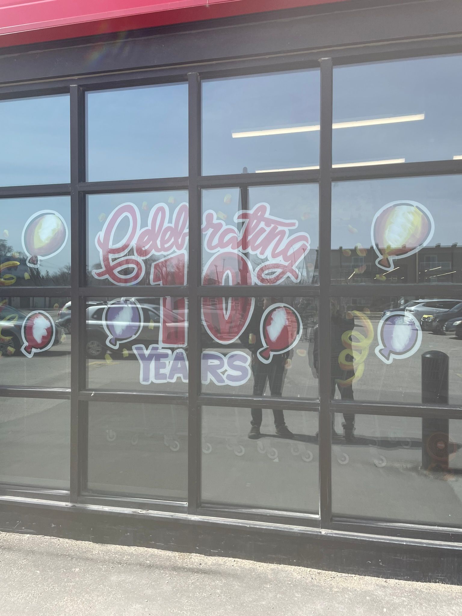 A store front with balloons painted on the windows