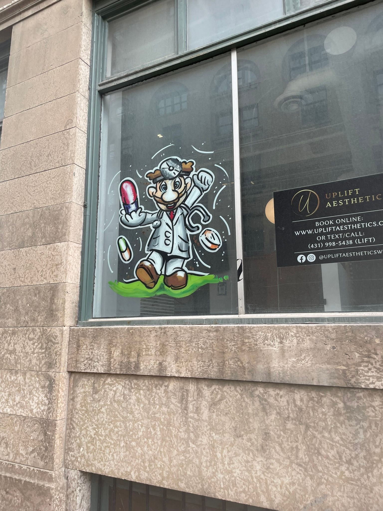 A cartoon of a man in a lab coat is painted on a window.