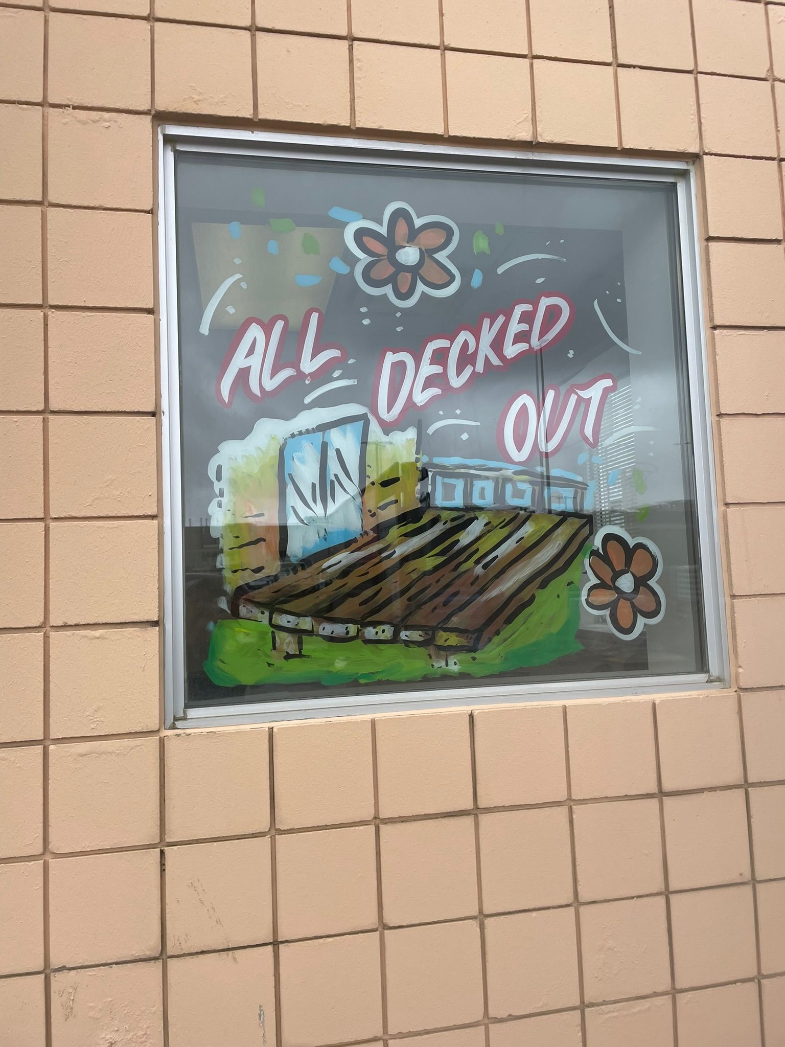 A window with a painting on it that says all decked out