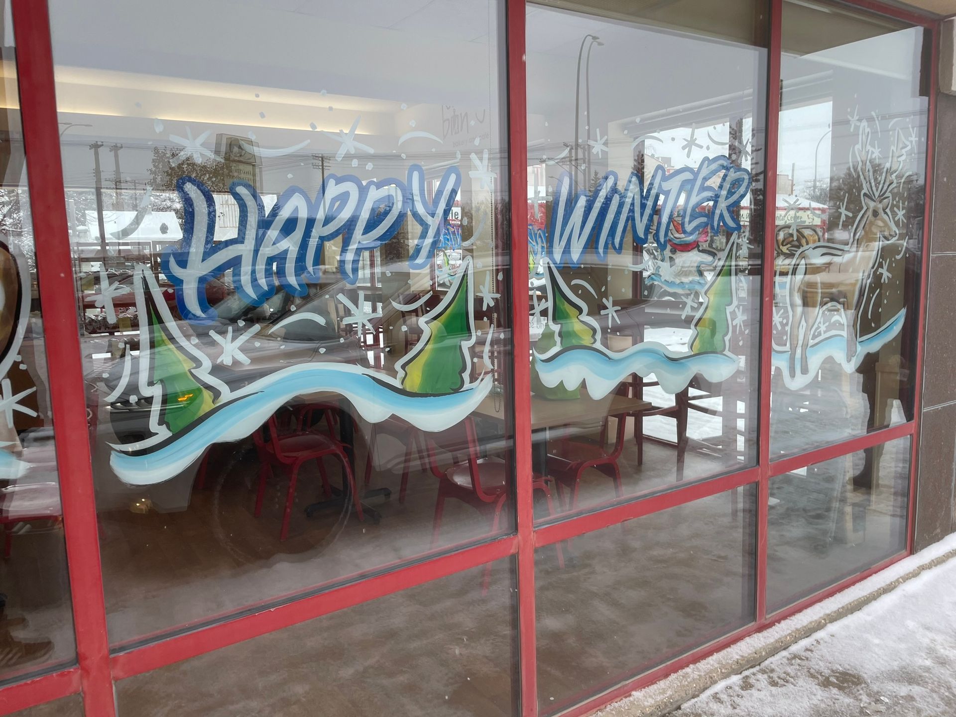 A window with graffiti on it that says happy winter