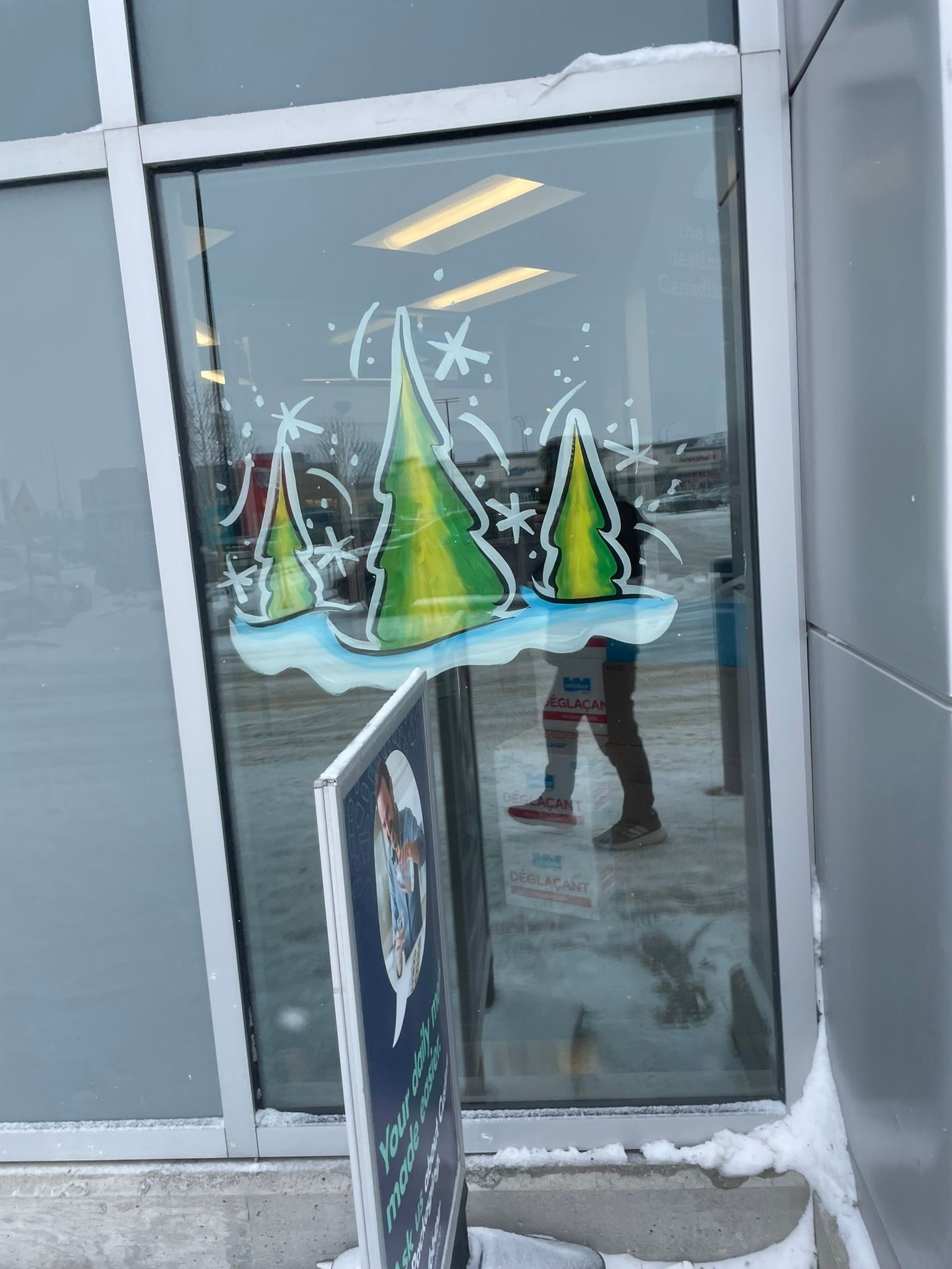 A window with christmas trees painted on it