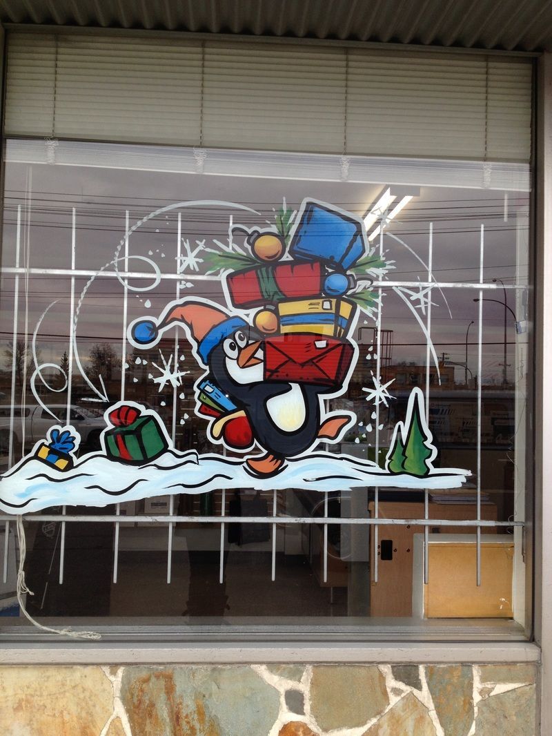 A window with a painting of a penguin carrying gifts