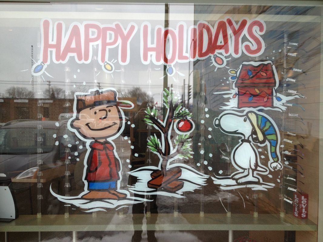 A window with peanuts characters and the words happy holidays painted on it