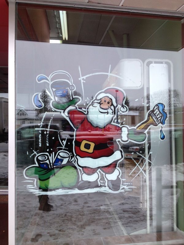 A window with a drawing of santa claus holding a brush
