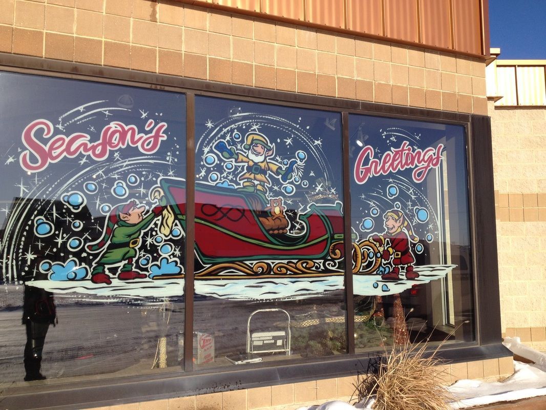 A window with a painting of santa in a sleigh and the words season 's greetings on it