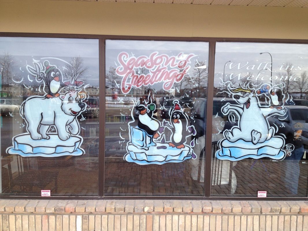 A window with three polar bears and penguins painted on it