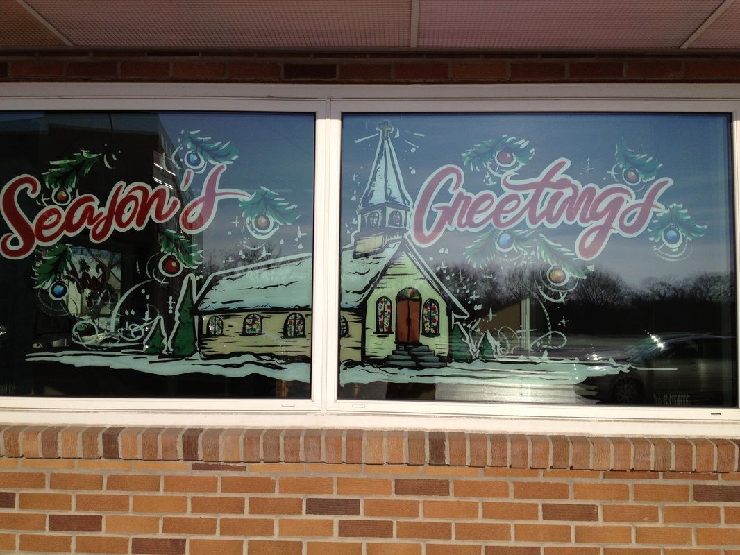 A window with a picture of a house and the words season 's greetings on it