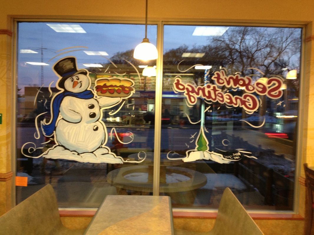 A window with a snowman holding a hamburger and the word sprite on it