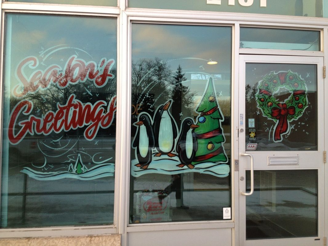 A window with penguins and a christmas tree on it