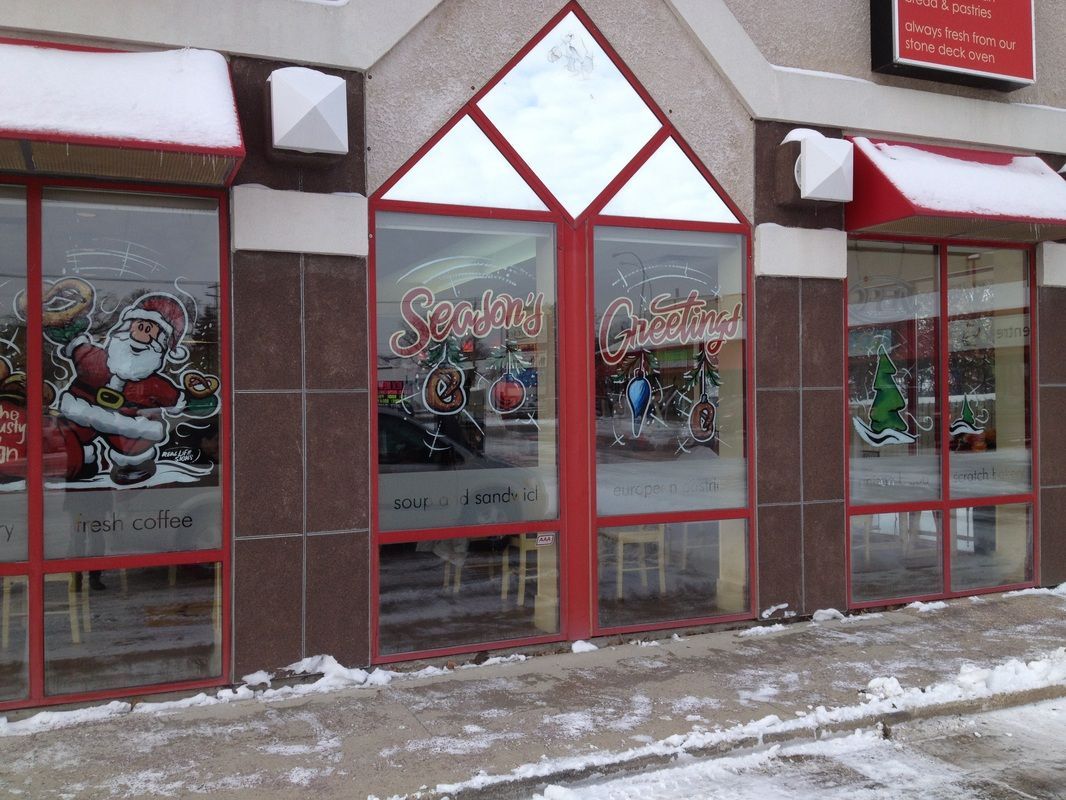 A store front with christmas decorations on the windows