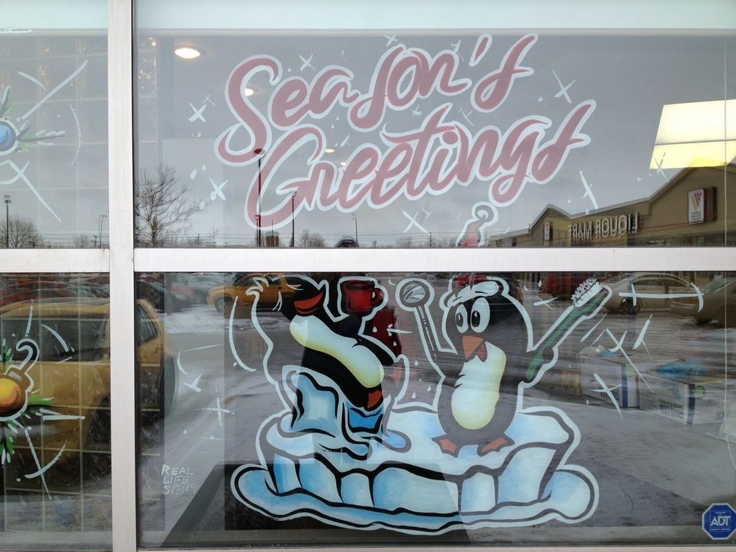 A window with a picture of a penguin and the words season 's greetings