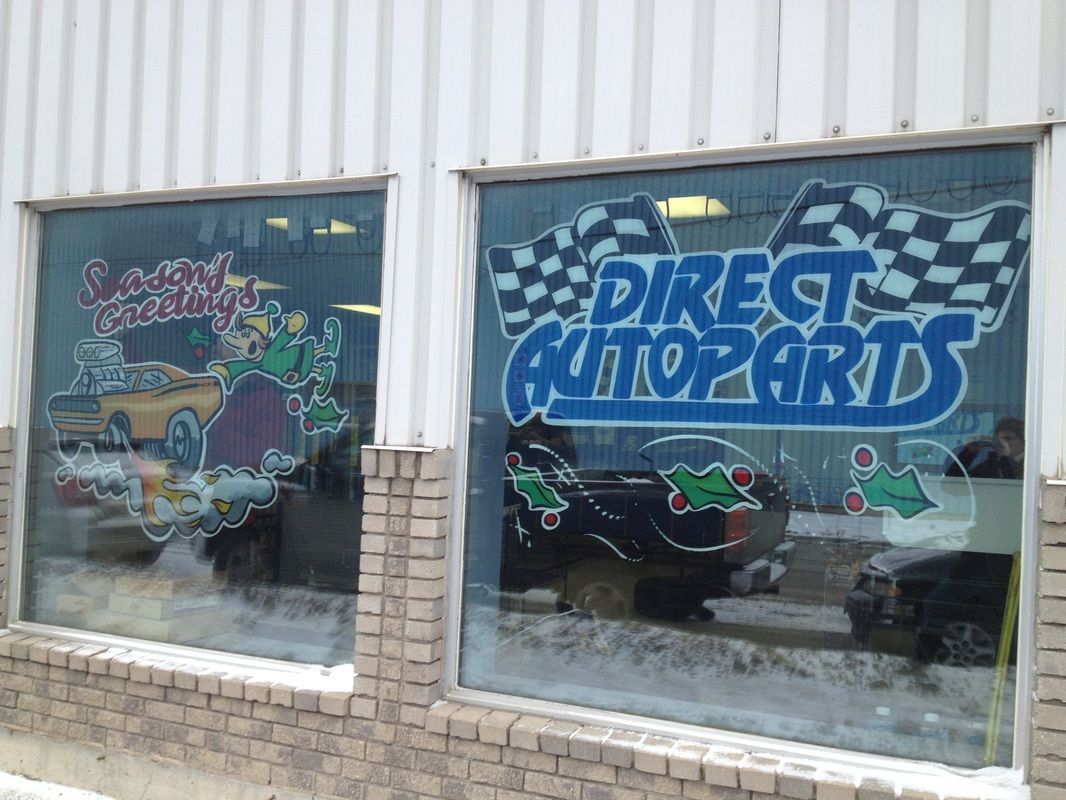 A car is reflected in the window of a direct auto parts store.