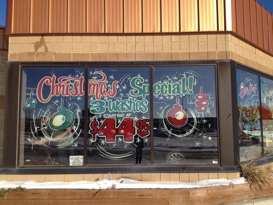 A store front with christmas decorations on the windows.