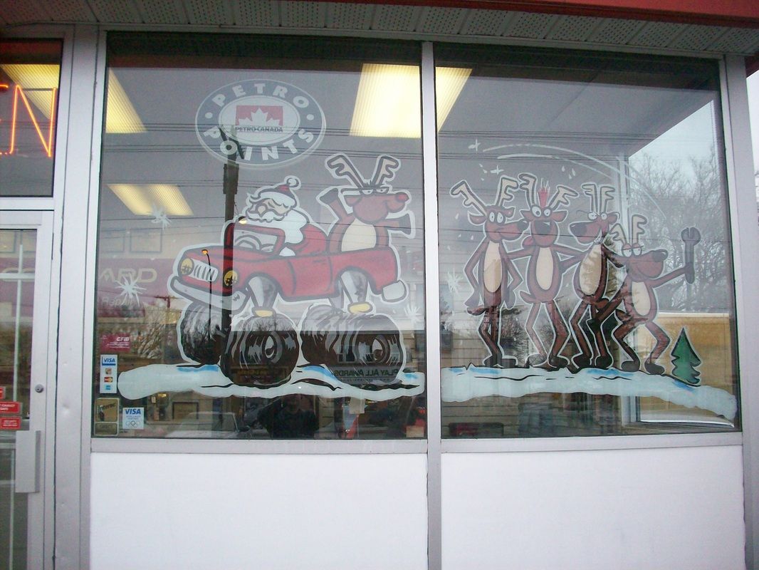 A window with a painting of santa and reindeer on it