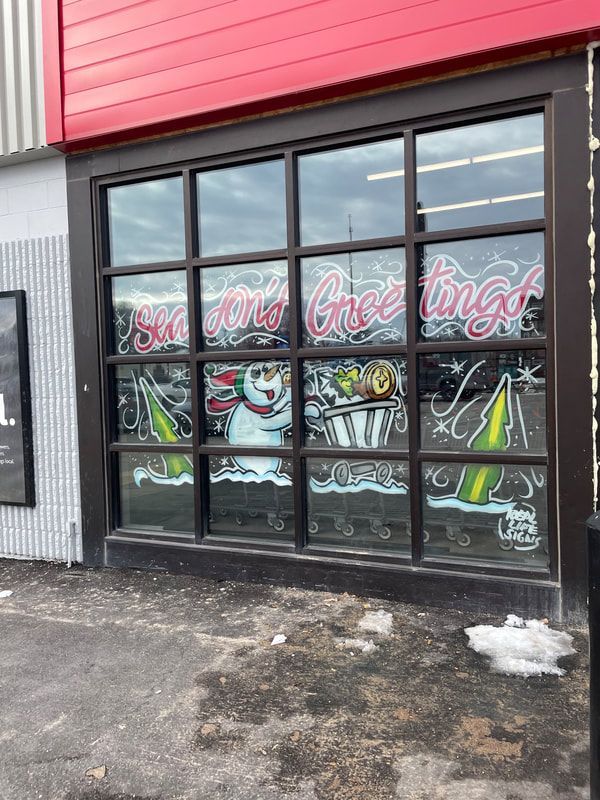 A store front with a christmas decoration on the windows.