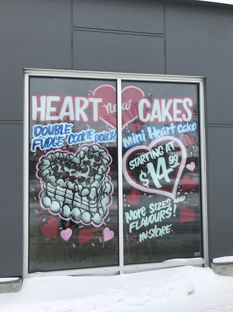 A window with a sign on it that says heart cakes