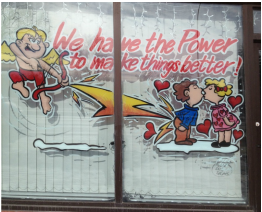 A window with a couple kissing and the words we have the power to make things better