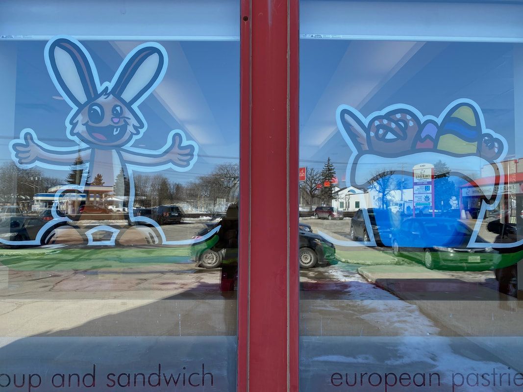 A window with a bunny and a cupcake on it.