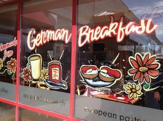 A window of a restaurant advertising german breakfast