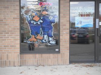 A brick building with a window with a picture of a duck on it.