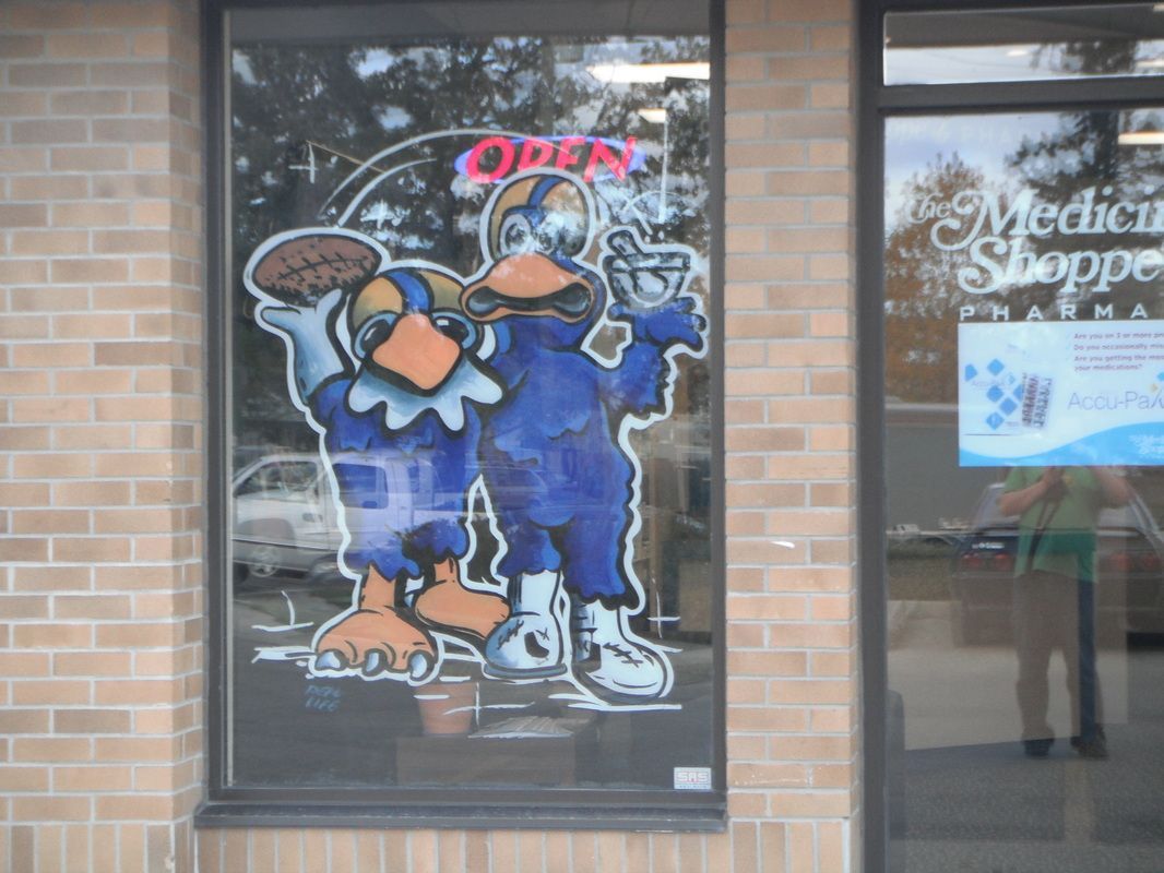 A window with a cartoon drawing of two birds and the words open on it