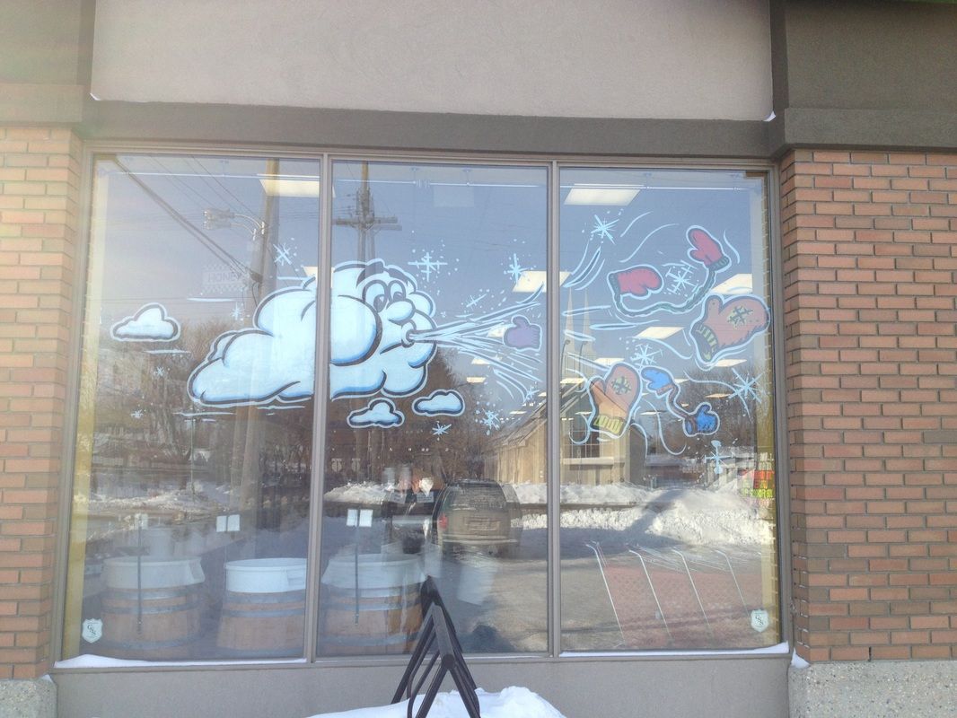A cloud is painted on the window of a brick building.