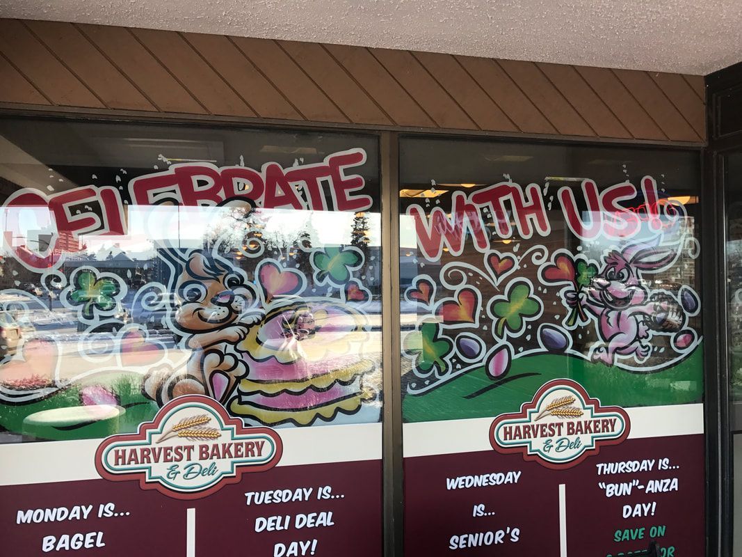 A window of a bakery that says celebrate with us