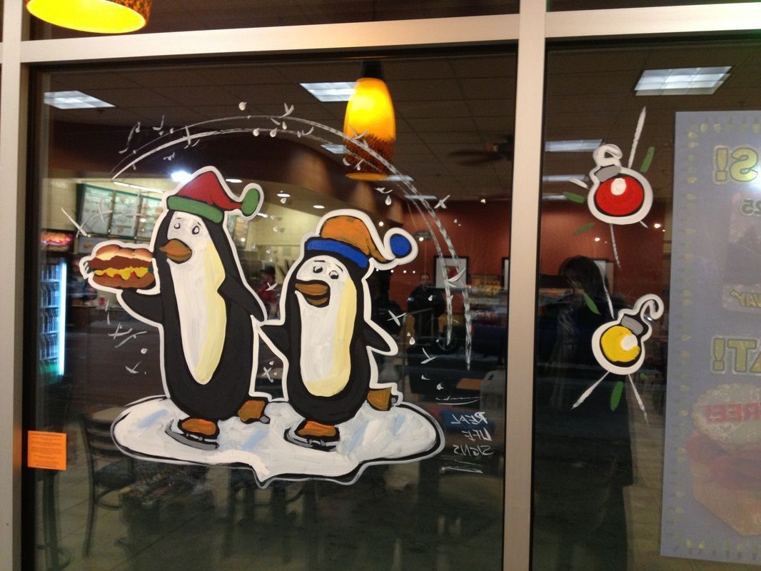 A window with a penguin holding a hamburger and the word uno on it