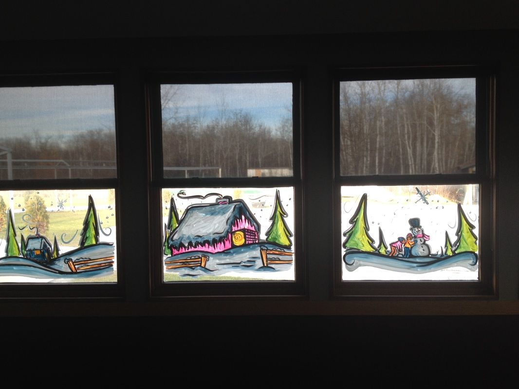 Three windows with paintings of a house , trees , and a snowman on them.