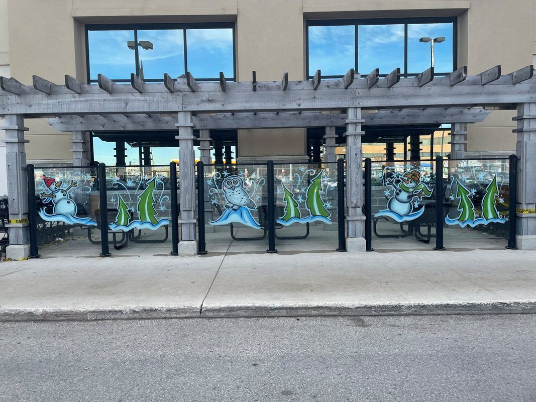A building with a pergola and a row of picnic tables in front of it.