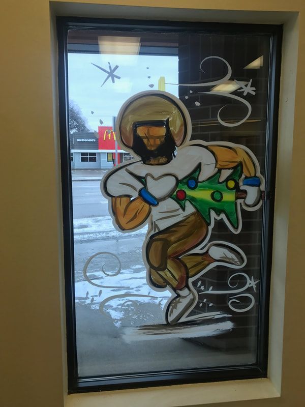 A window with a cartoon of a man holding a christmas tree