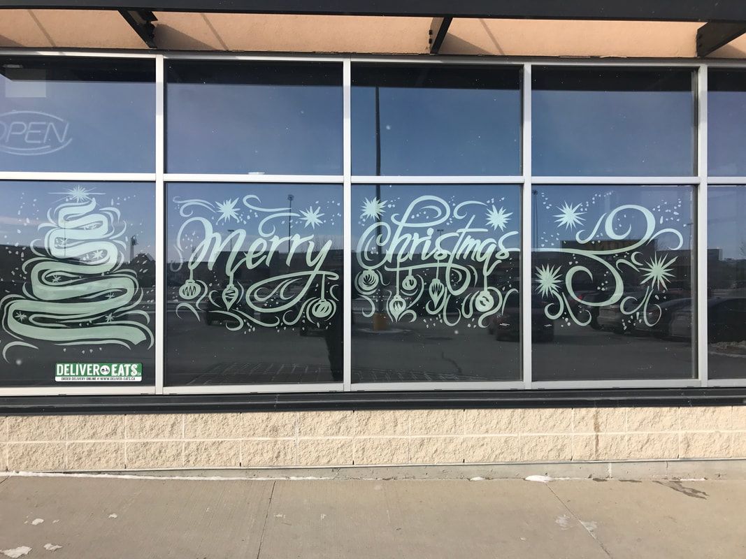 A window with a christmas tree and merry christmas written on it.