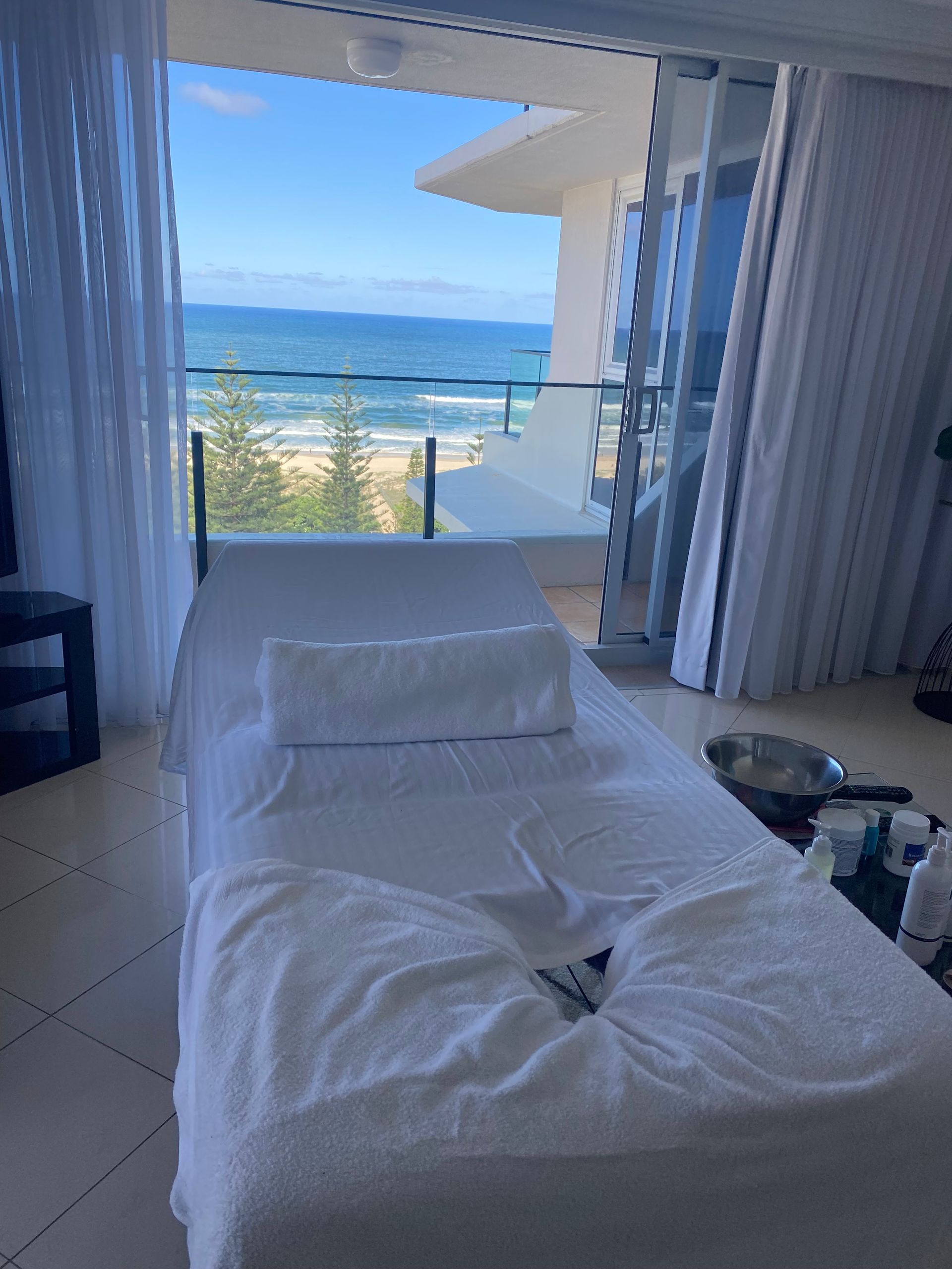 Massage Table Set up Near a Window With The Ocean In The Background — Soul Good Beauty in Miami, QLD