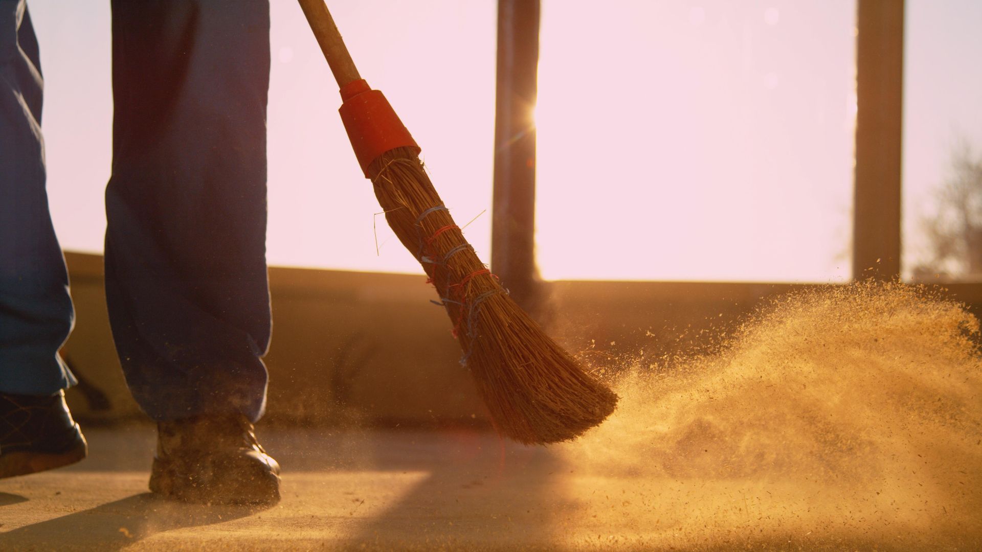 A person is sweeping the floor with a broom.