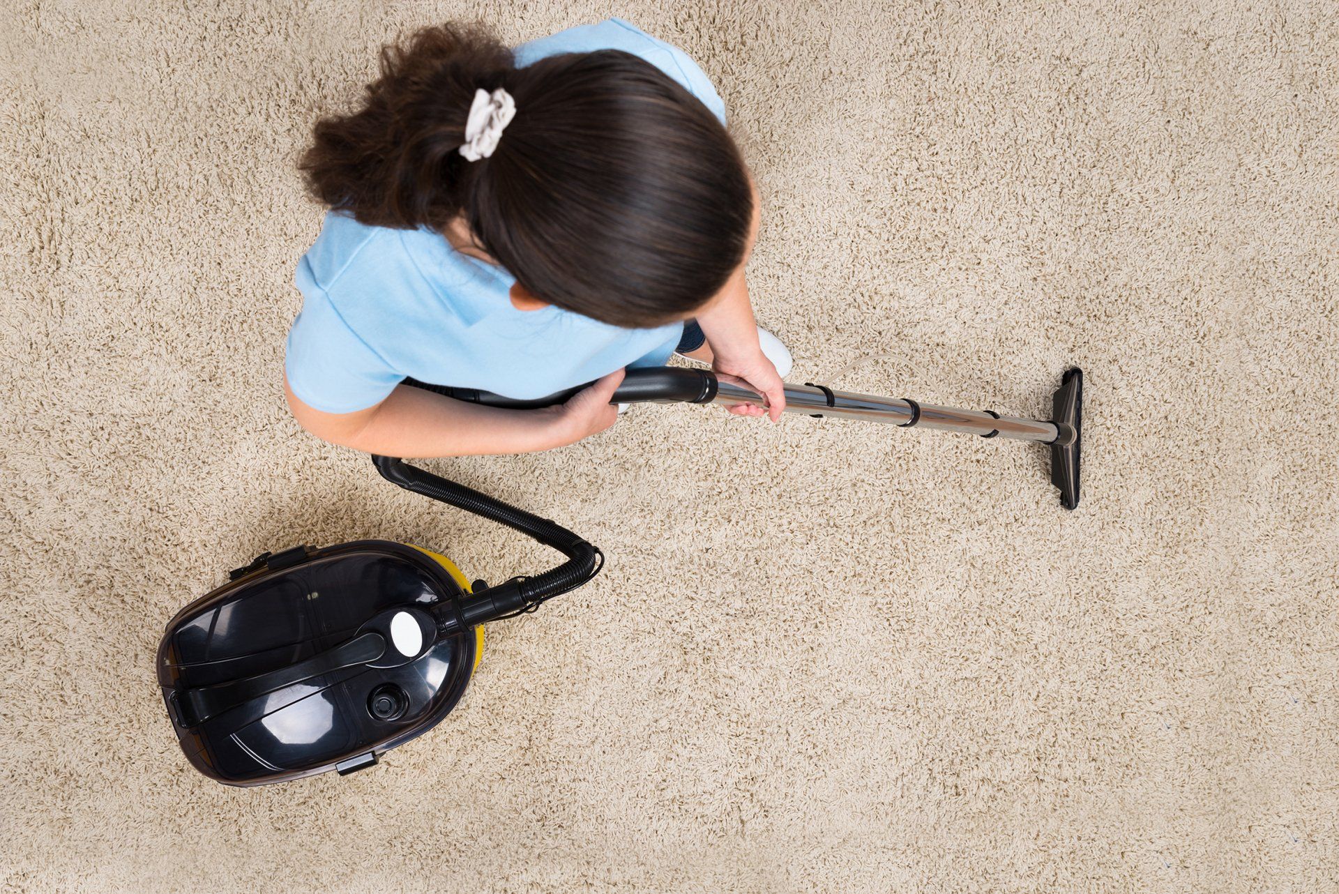 high angle view woman cleaning carpet