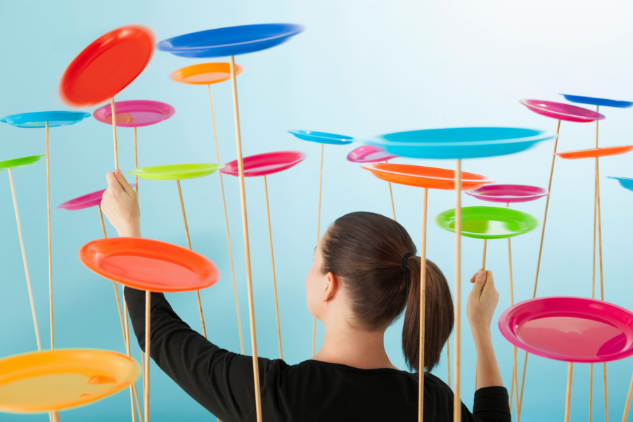 Person arranging colorful floating disks on sticks against a blue background