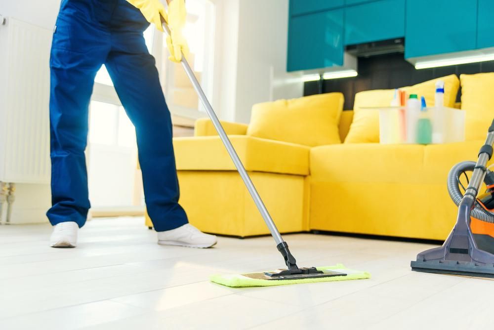 Person is Mopping the Floor in a Living Room — Active Cleaning Service Rutherford, NSW